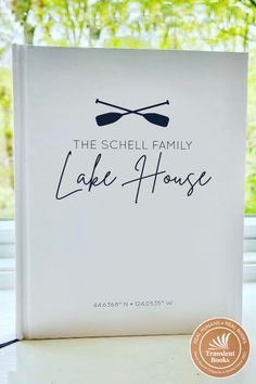 the schell family lake house book is sitting on a table with trees in the background