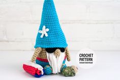 a crocheted gnome sitting on the ground