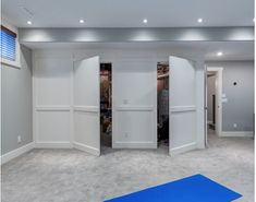 an empty room with white walls and blue mats on the floor in front of it