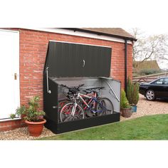 a car parked in front of a brick building with a bike mounted to it's side