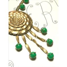 This is part of Chairish’s Costume Jewelry assortment.  Vintage Gold Green Statement Necklace 1970s Sunflower Dangles Beads  ------------------  Stylish gold necklace with beautiful green round beads...the middle pendant is a sunflower design...multiple green beads at the chain plus 5 dangles each ending with that same green bead encased in gold...secure closure.  Overall length of chain: 18"   Plus total pendant drop: 5.50" Green Dangle Necklace With Beads, Green Necklaces With Dangling Beads, Green Costume Jewelry Beaded Necklace, Green Round Beaded Necklaces For Party, Green Dangle Jewelry With Large Beads, Vintage Green Pendant Beaded Necklace, Vintage Green Dangle Jewelry, Green Bohemian Metal Beaded Necklaces, Green Bohemian Beaded Metal Necklace