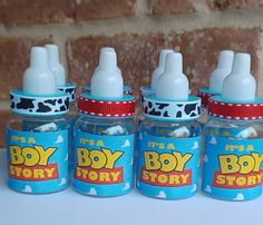 four small bottles filled with milk sitting on top of a white table next to a brick wall