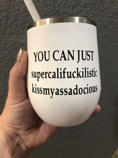 a person holding a white cup with words on it