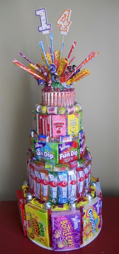 a multi - tiered cake made out of candy bars and candies with the number four on top