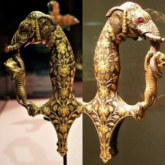 an elephant statue is on display in front of a glass case with gold designs and red eyes