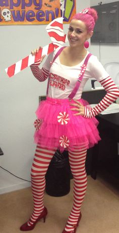 a woman dressed in pink and red holding a candy cane