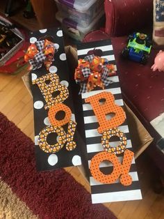 two cardboard letters decorated with polka dots and bows on top of each other in front of a couch