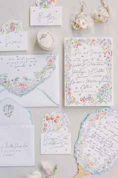 the wedding stationery is laid out on top of each other, including cards and envelopes