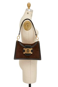 Tod's - Aoy Chain Emblem Shoulder Bag | Mitchell Stores Designer Handheld Bags With Gold-tone Hardware, Designer Handheld Business Shoulder Bag, Luxury Tan Bucket Shoulder Bag, Luxury Brown Shoulder Bag With Gold-tone Hardware, Designer Rectangular Shoulder Bag With Gold-tone Hardware, Designer Satchel With Gold-tone Hardware For Daily Use, Designer Tan Shoulder Bag, High-end Brown Shoulder Bag With Gold-tone Hardware, Designer Tan Bag With Branded Hardware