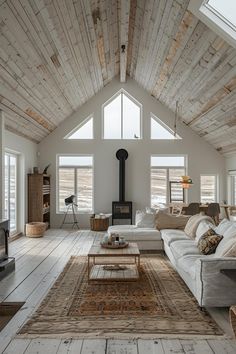 a living room filled with furniture and a fire place in the middle of an open floor plan