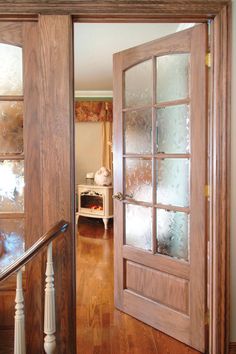 an open wooden door with frosted glass on the front and side doors to another room