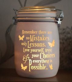 a glass jar that has some writing on the inside of it and butterflies around it