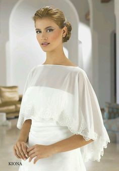 a woman wearing a white dress with an off the shoulder top and cape over her shoulders