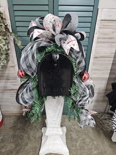 a mailbox decorated with wreaths and christmas decorations in front of a green door