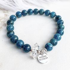 This soothing mala bracelet features blue apatite gemstone beads, one glowing Herkimer diamond and your choice of gold, silver or rose gold Buddha Blossom tag and accent beads.Gemstone beads are about 8mm. Bracelet size options are 7, 7.5, and 8 inches. ***Average size for a female is 7.5 inches.***If you would like the size adjusted in any way just send me a message when ordering. Each item arrives in a lovely little gift box. 😘❤️ xoxo,Amy*We at Buddha Blossom Jewels believe in the power of in Apatite Beaded Bracelets As Gift, Gold Buddha, Birthstone Stacking Rings, Raw Stone Ring, Yoga Bracelet, Bracelet Crystal, Mala Bracelet, Bracelet Blue, Stacked Jewelry