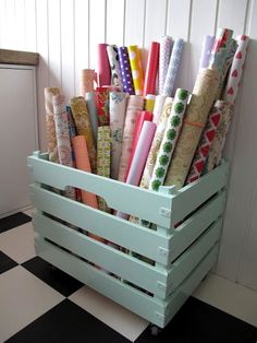 a wooden crate filled with lots of wrapping paper