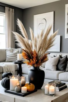 a living room filled with lots of white furniture and candles on top of a coffee table