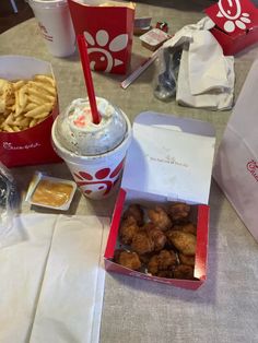 a table topped with lots of food next to cups and sauces on top of it