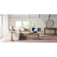 a living room filled with furniture and a large mirror on the wall above it's windows