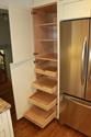 a kitchen with wooden shelves and stainless steel refrigerator