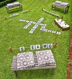 an outdoor seating area with chairs and letters on the grass