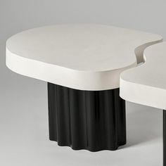 two tables with black and white bases are shown