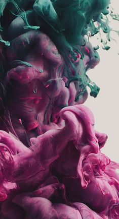 pink and green ink mixed together in water