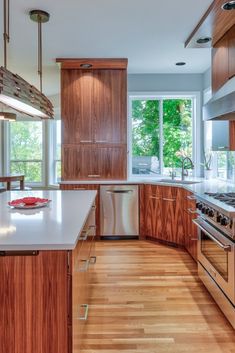 a large kitchen with wooden cabinets and stainless steel appliances, along with hardwood flooring