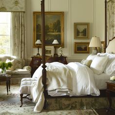 a large bed sitting in a bedroom next to a window