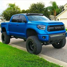 a blue truck parked on the side of a road