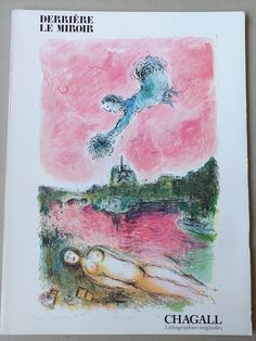 a book with an image of a woman laying on the ground in front of a pink sky