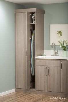 an open closet with clothes hanging on the door and a sink in front of it