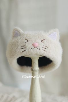 a close up of a cat head on a small white object with a pink nose