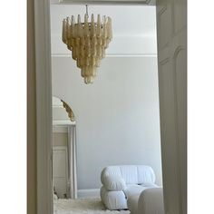 a chandelier hanging from the ceiling in a room with white walls and carpet