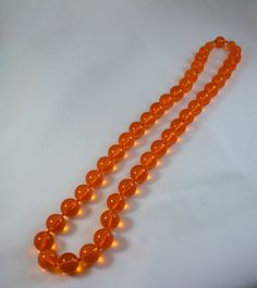 "Vintage c1950's tangerine orange clear lucite bead necklace Excellent condition 1/2\" diameter bead, except for the bead adjacent to the clasp bead, those are 3/8\" diameter and 1/4\" diameter The clasp bead is 1/2\" 26 inches long" Vintage Orange Beaded Necklaces For Formal Occasions, Orange Single Strand Beaded Necklace, Orange Single Strand Beaded Necklace With Round Beads, Formal Orange Single Strand Necklace, Vintage Orange Round Beads Necklace, Vintage Orange Round Bead Necklace, Vintage Orange Necklace With Round Beads, Orange Costume Jewelry Beaded Necklace, Classic Orange Round Necklace