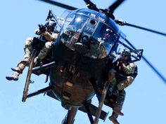 soldiers climbing into the back of a helicopter