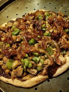 a pizza sitting on top of a pan covered in meat and veggie toppings