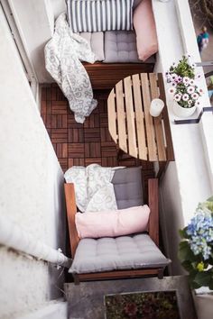 an overhead view of a small balcony with furniture and flowers on the table in front of it