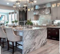 a large kitchen with marble counter tops and chairs