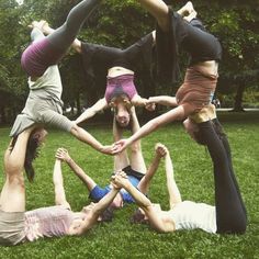 a group of people standing in the middle of a circle on top of each other