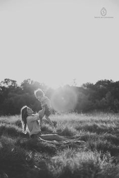 a mother and her child playing in the grass with the sun shining down on them