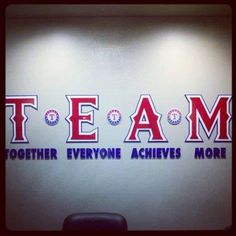 there is a sign on the wall that says team together everyone achieve's more