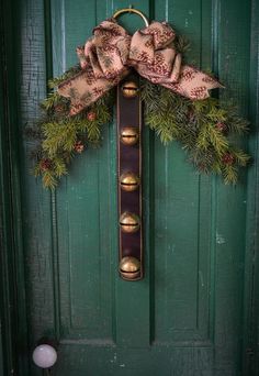 a green door with a wreath and bells on it