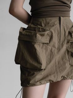 Short length skirt made from nylon. Zippered closure. Large oversized pocket details with drawstring hemline. Model is in MINUSEY S. ✔️ Free worldwide express shipping over $100✔️ Loved by 6,500+ customers✔️ Limited edition collections, maximum style⠀⠀⠀⠀⠀⠀⠀⠀⠀Stay ahead of the trend with can’t-find-anywhere-else staples. Your closet will thank you 💕 * MINUSEY S = EU 34, US 2* MINUSEY M = EU 36, US 4* 100% Nylon* Dry clean* Made in Korea - Model Height: 168cm/5'6" (US2, EU34) Utility Cargo Skirt With Multiple Pockets In Khaki, Khaki Utility Cargo Skirt With Side Pockets, Spring Nylon Cargo Skirt With Pockets, Utility Cargo Skirt With Pockets, Khaki Cargo Skirt With Side Pockets, Utility Mini Skirt With Patch Pockets, Utility Cargo Skirt With Patch Pockets, Utility Mini Skirt With Side Pockets, Utility Mini Cargo Skirt With Pockets