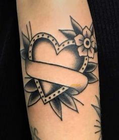 a tattoo with a heart and ribbon on it