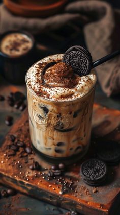 an oreo milkshake with whipped cream and chocolate on the rim, surrounded by cookies