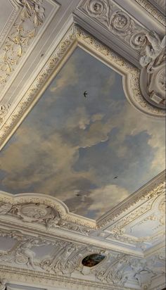 the ceiling is painted with clouds and birds