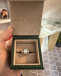 a person is holding up a ring in a box that says,'minka jevele '