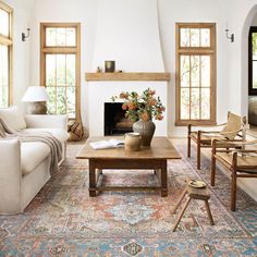 a living room filled with furniture and a fire place in the middle of a room