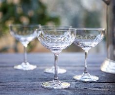 three wine glasses sitting on top of a wooden table